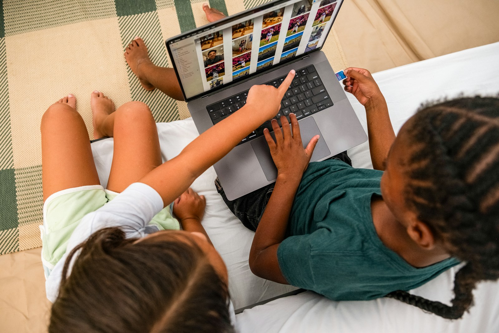 Two children looking at a laptop screen together